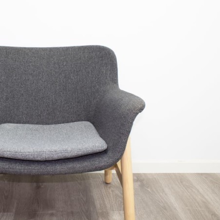 Sillón de espera tapizado en gris con patas de madera