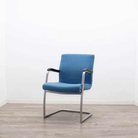 Silla confidente tapizada en azul con brazos fijos