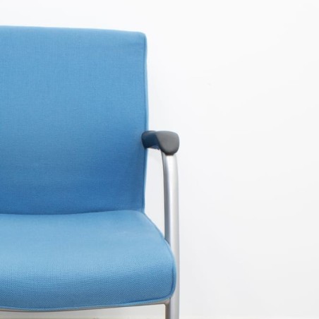 Silla confidente tapizada en azul con brazos fijos