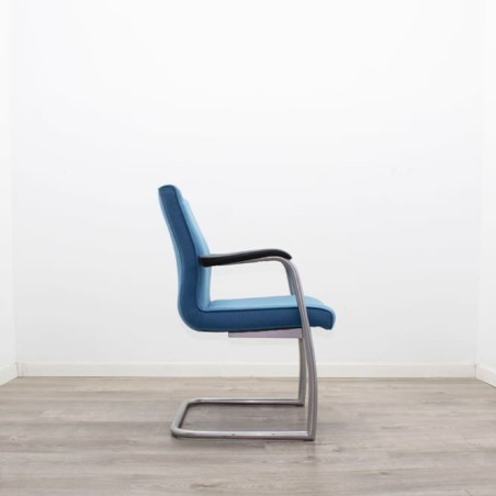 Silla confidente tapizada en azul con brazos fijos