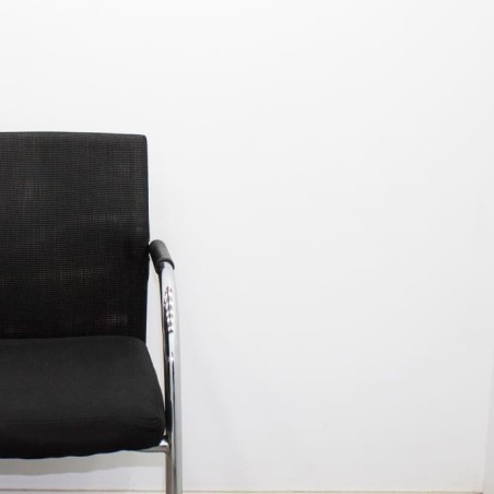Silla confidente negra con respaldo de malla en negro