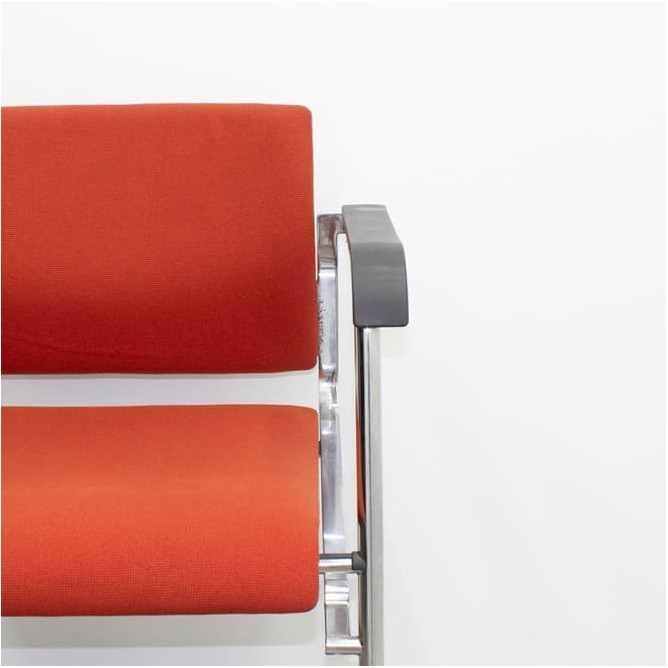 Silla confidente tapizada en rojo y base patín cromada