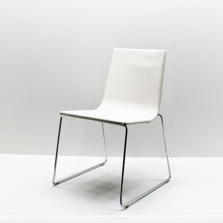 silla confidente Andreu World beige con base patin de varilla de acero en acabado cromo brillo.