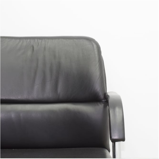 Silla confidente en piel con brazos y base patín